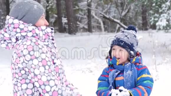 特写妈妈和宝宝在冬天的公园或森林里玩耍扔雪体验快乐的情绪视频的预览图
