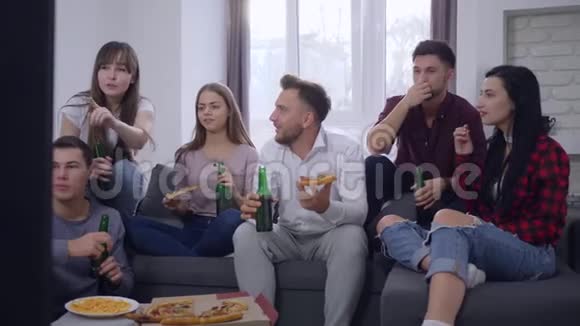 家庭聚会上友好的关系快乐的朋友男人和女人交流用啤酒和披萨放松同时视频的预览图
