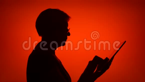 高级女性剪影在红色背景上使用平板电脑女性在网上浏览个人资料视频的预览图