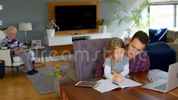 父亲帮助女孩在客厅学习视频的预览图