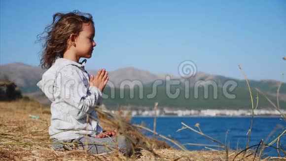 可爱的小孩咕噜独自坐在湖岸的莲花中视频的预览图