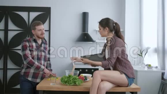 健康的食物年轻人在午餐时准备有用的素食女人坐在厨房的桌子上桌上放着平板电脑视频的预览图