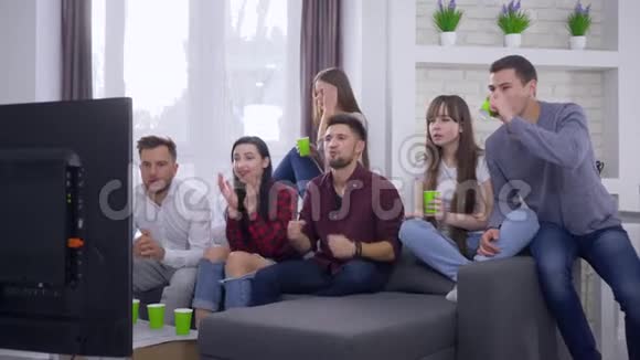 电视体育比赛兴奋的球迷朋友与女友一起观看体育比赛为最喜爱的胜利而欢欣鼓舞视频的预览图