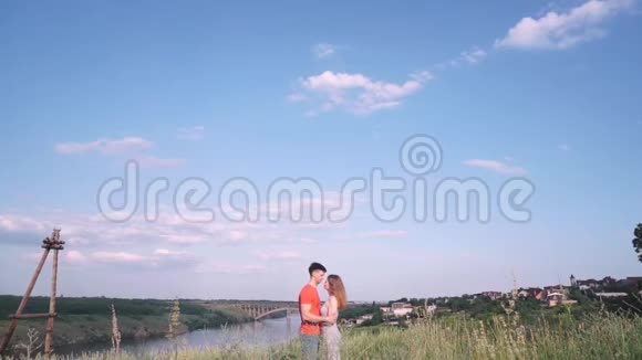 总计划美丽的男人和女人亲吻在框架的中心桥河树草房子靠岸视频的预览图