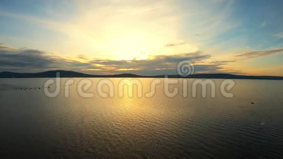 背景山色夕阳下平静海水的鸟瞰图视频的预览图