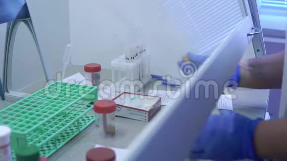 实验室助理用吸管从瓶子中吸取透明液体视频的预览图