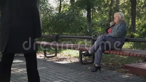 一个成年男子走近坐在长凳上的女人视频的预览图