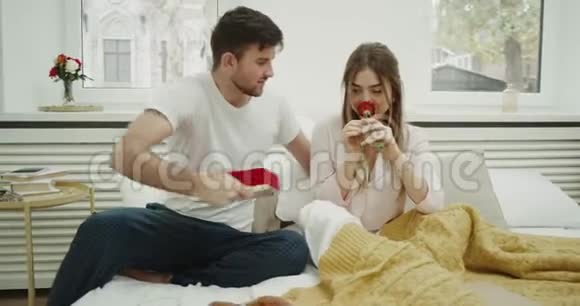 情人节那天早上一对年轻夫妇在床上给他女朋友送礼物4k视频的预览图