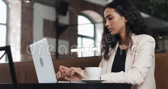 年轻的商务女性在现代办公室的笔记本电脑上工作她笑得很迷人视频的预览图