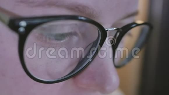 眼镜中的女性眼睛特写镜头反映了一个工作的电脑屏幕视频的预览图