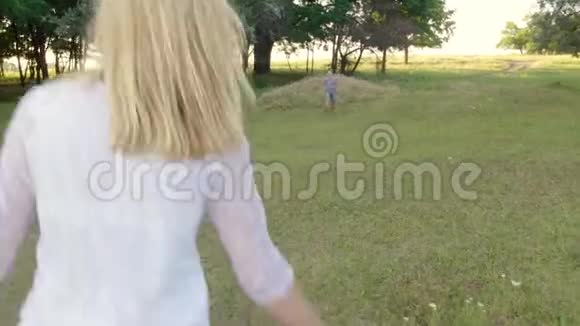 一个男孩沿着公园跑到他妈妈怀里视频的预览图
