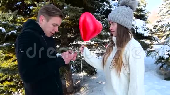 手里拿着一部手机不注意那个用气球打他心脏形状的女孩这就是视频的预览图