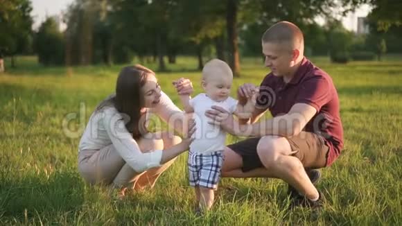 母亲把她的第一个儿子放在公园里父亲的肩膀上视频的预览图