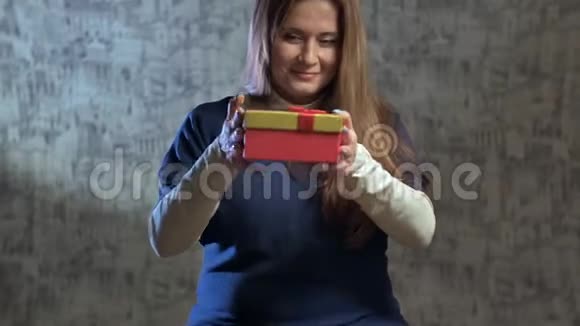 美丽的女孩打开礼物视频的预览图