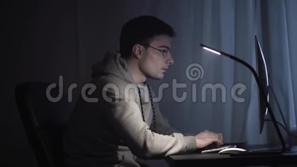 一个晚上在电脑上工作的疲惫的年轻人视频的预览图