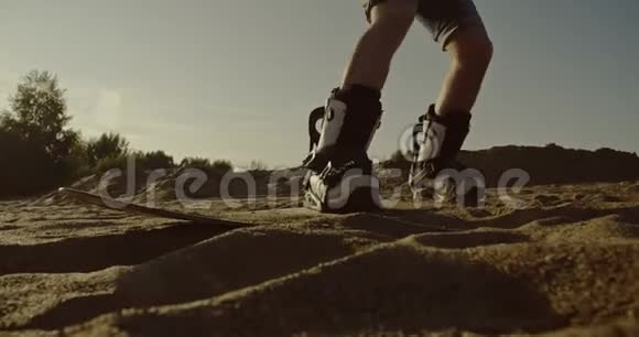 日落时分年轻人在沙漠中的沙板上跳跃体育旅游生活方式商业广告概念视频的预览图