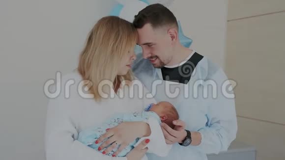 快乐年轻的父母与新出生的婴儿触摸他们的额头享受婴儿睡觉的时刻视频的预览图