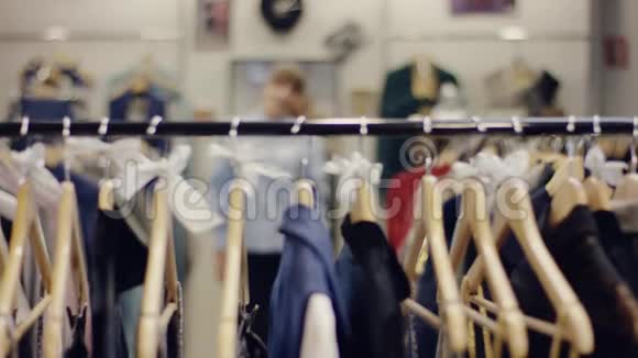 快乐的年轻女购物者从一家服装店的货架上拿走了很多衣服然后把它带到了试衣间视频的预览图