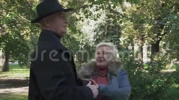 成熟的女人来到高大的男人面前在公园里抓住他的手视频的预览图