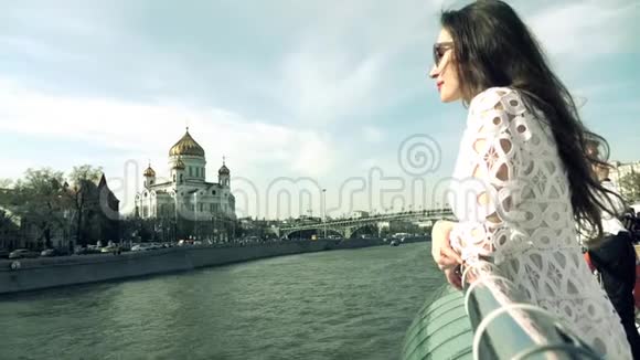 布鲁内特女士穿着白色礼服看着莫斯科的救世主大教堂视频的预览图
