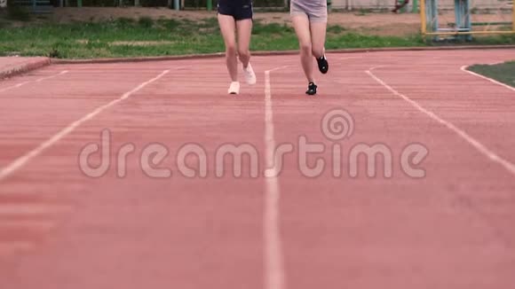 两个穿短裤的苗条运动女孩在体育场里慢动作地跑来跑去视频的预览图