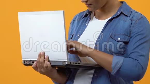 年轻女性在笔记本电脑上输入信息并显示OK标志在线应用程序视频的预览图