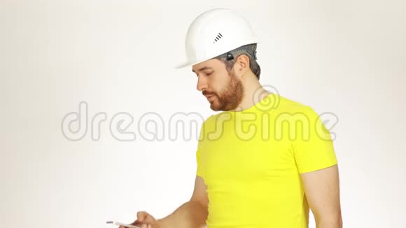 穿着黄色T恤的英俊建筑工程师或建筑师用手机说话视频的预览图
