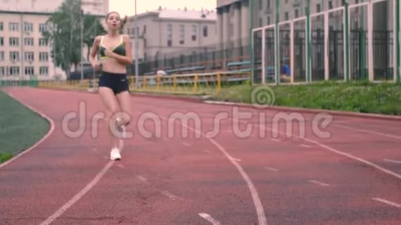 运动型黑发女郎厌倦了跑步她穿着运动服在体育场跑步视频的预览图