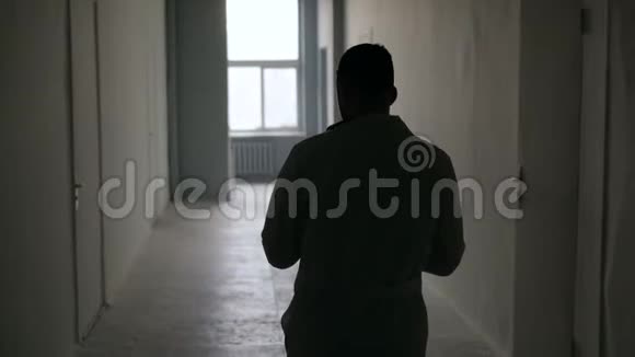 一位医生的剪影沿着一家黑暗的医院走着视频的预览图