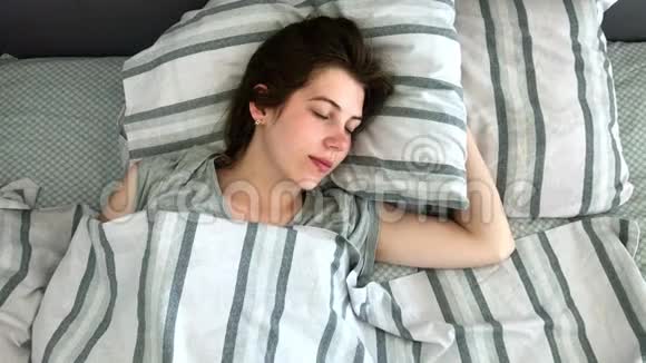 清晨美丽的黑发少女迷人地睡在床上甜美温馨的少女视野视频的预览图