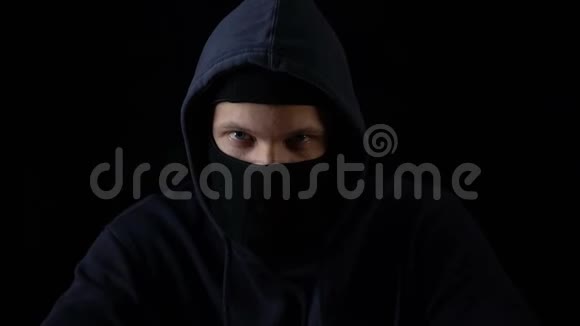 疯子犯罪后摘下巴拉克拉瓦面具黑背景视频的预览图