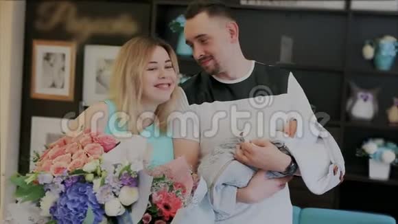 年轻快乐微笑的父母接受祝贺并与新生儿合影留念带花的年轻母亲视频的预览图