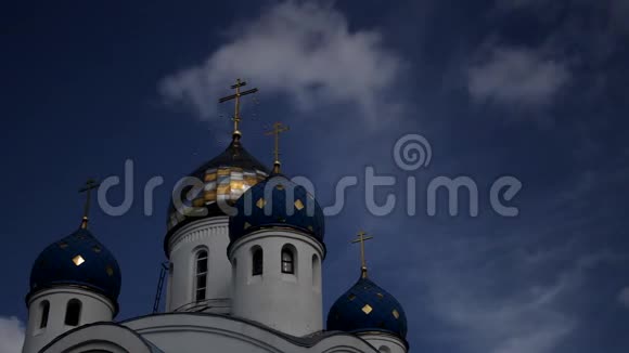 东正教金色和蓝色圆顶的低角度视图在明亮的蓝天下被太阳照亮的十字架这个视频的预览图