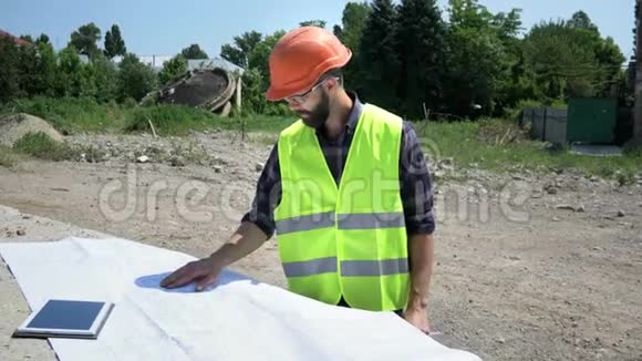 胡子建筑工程师在橙色头盔分析图纸施工准备视频的预览图