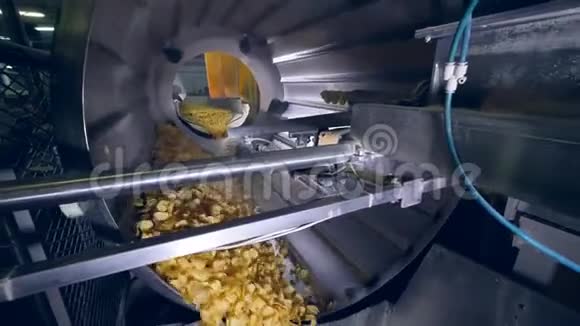 工厂设备在机器中旋转薯片增加风味增强剂视频的预览图