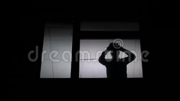 窗前的剪影戴上巴拉克拉瓦准备犯罪视频的预览图