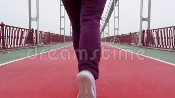 近距离拍摄一个穿着白色鞋子从摄像机里跑出来的女孩慢动作视频的预览图