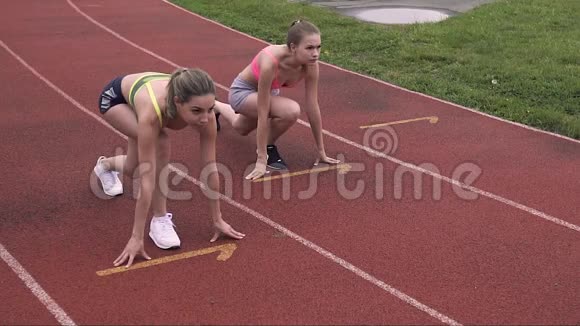 两个漂亮的女运动员在体育场的起点位置上的完全优势青少年健康运动的人观念视频的预览图