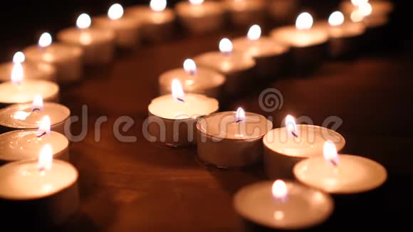 许多蜡烛火焰在黑暗中发光创造了一种精神氛围视频的预览图