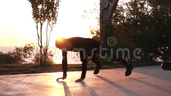 一个在户外训练黑色运动服的年轻运动员健康的生活方式理念男人用跳跃和俯卧撑视频的预览图
