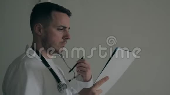 医生在黑暗的医院签文件视频的预览图