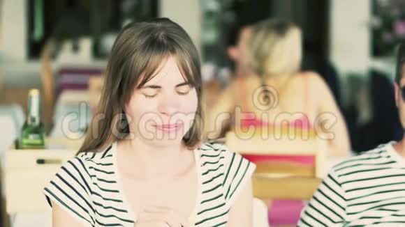 年轻的美女在咖啡馆里用吸管喝冷饮视频的预览图
