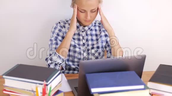 在笔记本电脑上工作时女孩按摩她的头视频的预览图