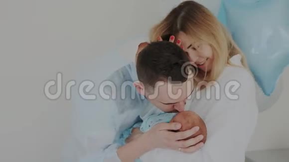 年轻快乐的父母给予新生的爱和关怀分娩后的幸福家庭住院视频的预览图