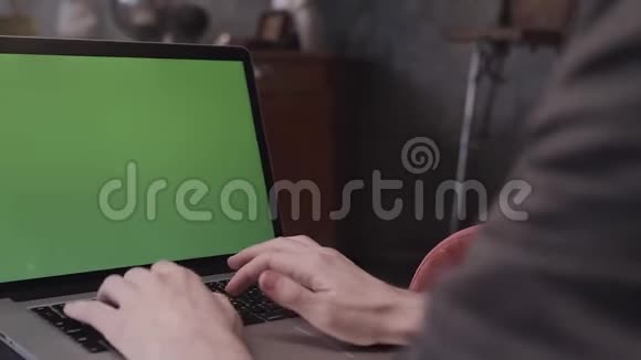 用一个空白的绿色可编辑屏幕关闭年轻商人手在笔记本电脑键盘上打字的后视镜股票视频的预览图