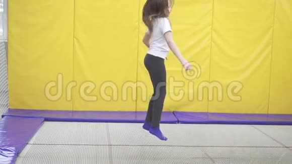 快乐的少年女孩跳在蹦床上视频的预览图