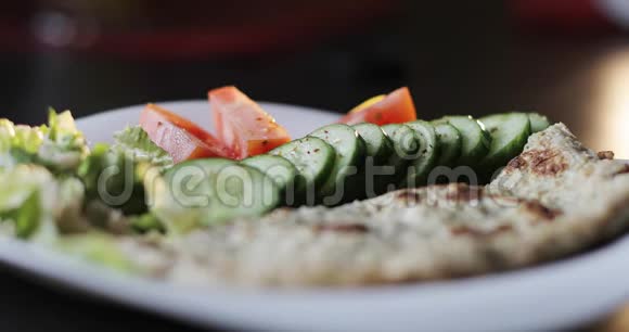 调料倒在一盘蔬菜绿色沙拉和燕麦煎饼上视频的预览图