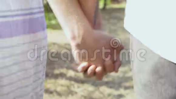 在公园或花园里散步的情侣牵手男人和女人一起在户外玩后景视频的预览图