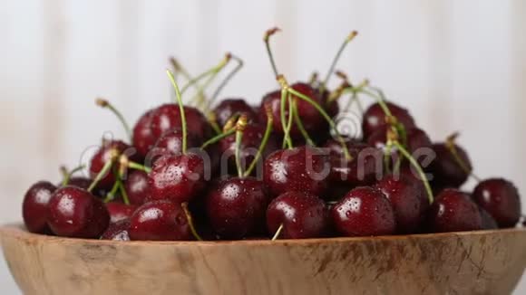 新鲜成熟多汁的樱桃放在木碗里旋转放大食物背景视频的预览图