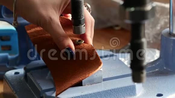 女工匠使用压力机在geniune皮革产品上安装金属铆钉闭合视频的预览图